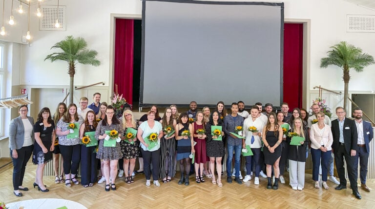 Aktuelles 10 Die Absolventinnen und Absolventen vor der großen Bühne.