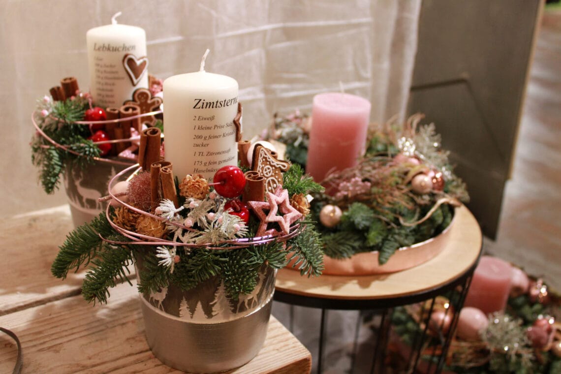 Ein Adventsgesteck mit Rezept auf den Kerzen.