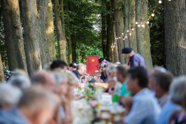 Aktuelles 7 Menschen essen an einer langen Tafel